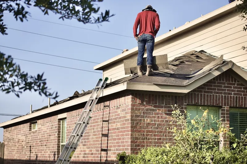 Professional roofer working on a residential roof in Perry